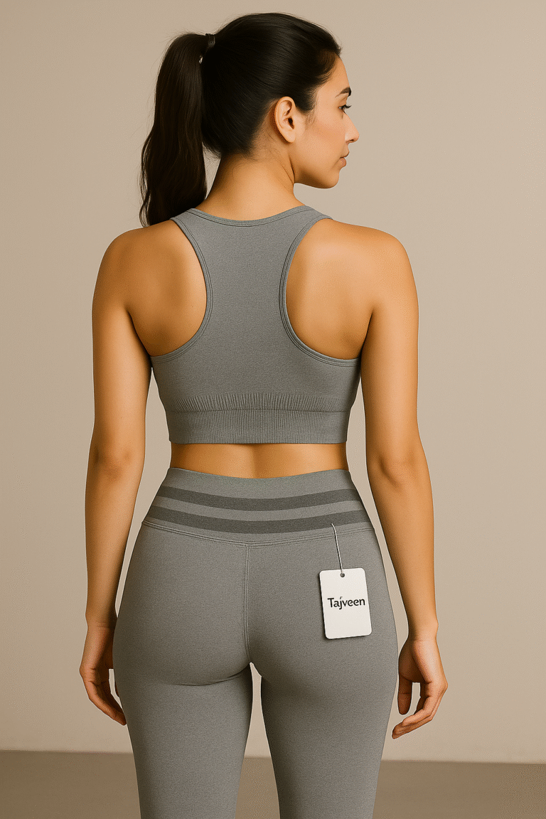 Woman wearing a gray sports bra and leggings with a visible brand tag on a beige background