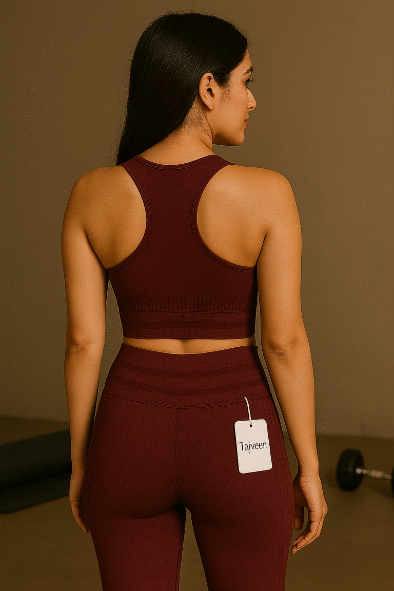 Woman wearing a maroon athletic outfit with a visible brand tag, standing against a plain background.