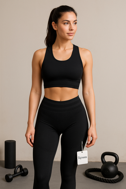 Woman wearing a black athletic outfit with a tag, standing in a gym setting.